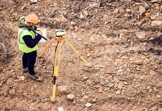Surveyor performing field measurements on site